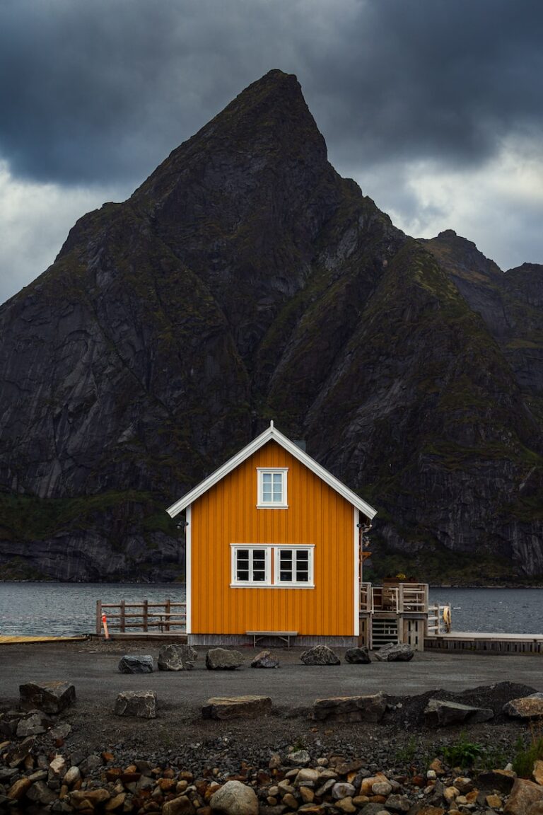 a small orange house sitting in front of a mountain